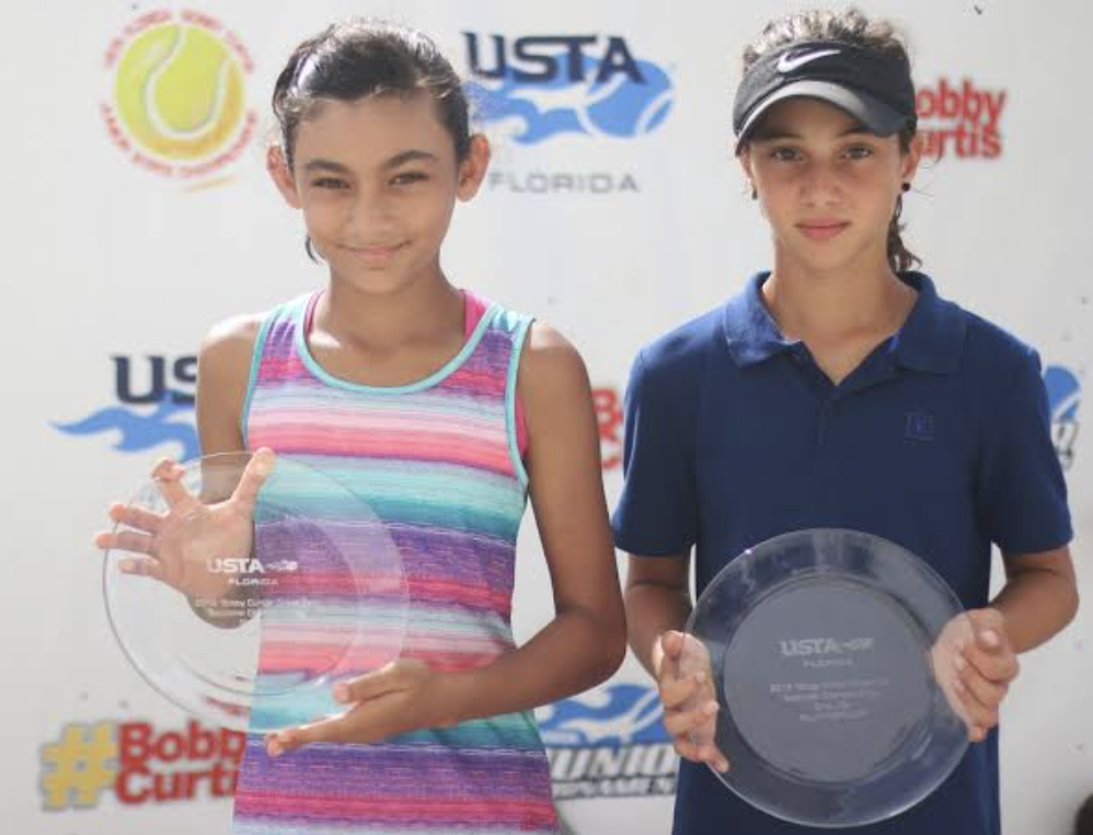 Riddhi Thakur holding the 2019 Bobby Curtis championship trophy beside finalist Zara Kirkan