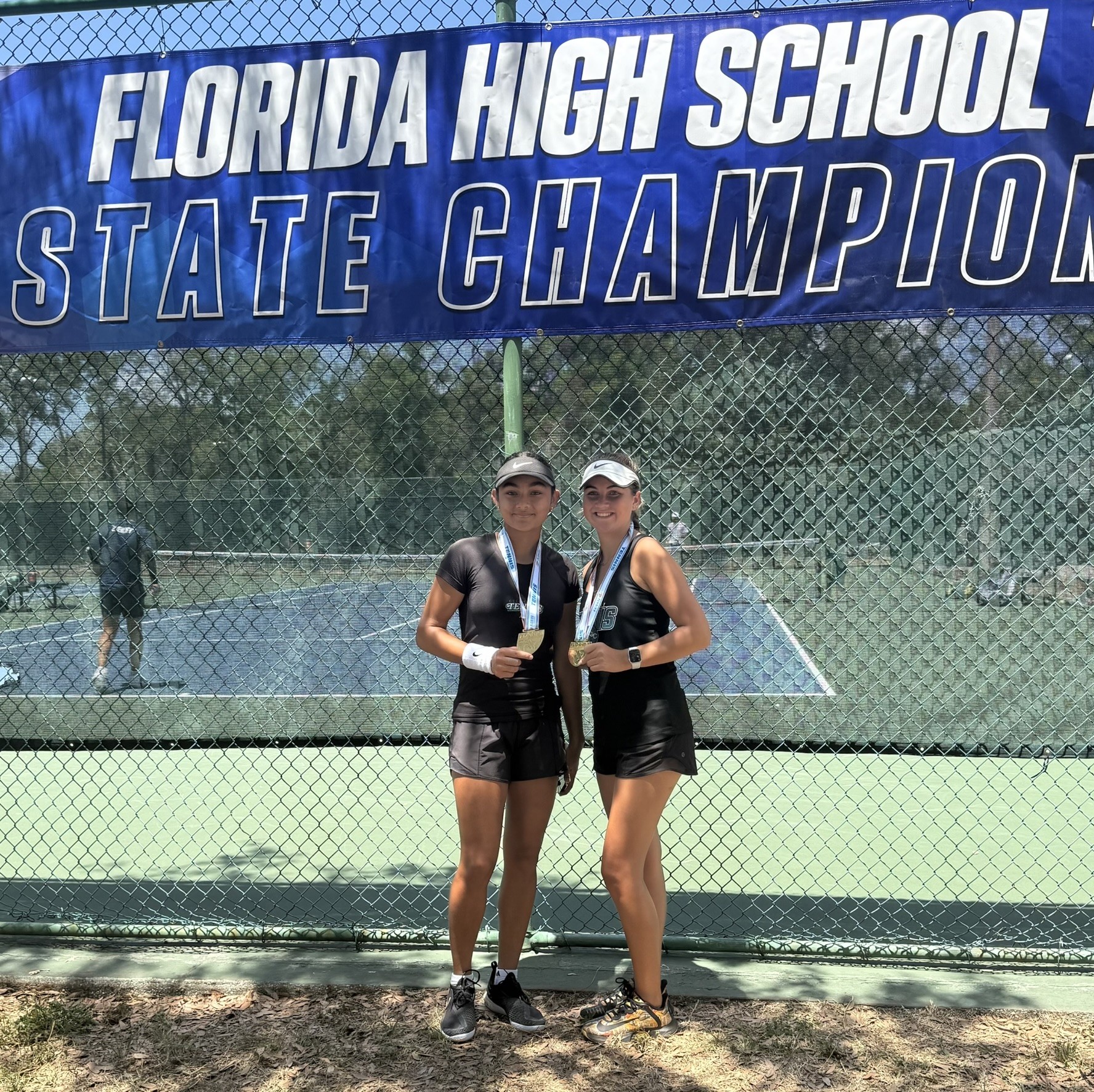 Riddhi Thakur and Faith Valentine wearing their 2025 Florida state doubles championship medals